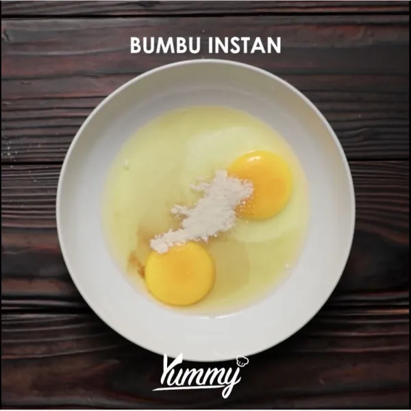 Kocok dua buah telur dengan setengah bagian bumbu mie instan.