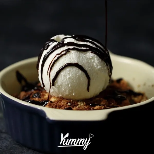 Angkat, beri 1 scoop ice cream vanilla lalu siram dengan saus coklat dan buah ceri.