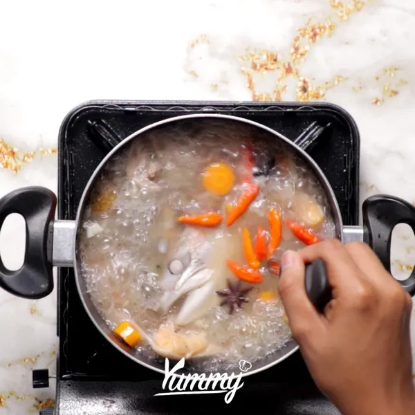 Masukkan ikan, garam, lada hitam, dan cabai rawit. Masak hingga mendidih.