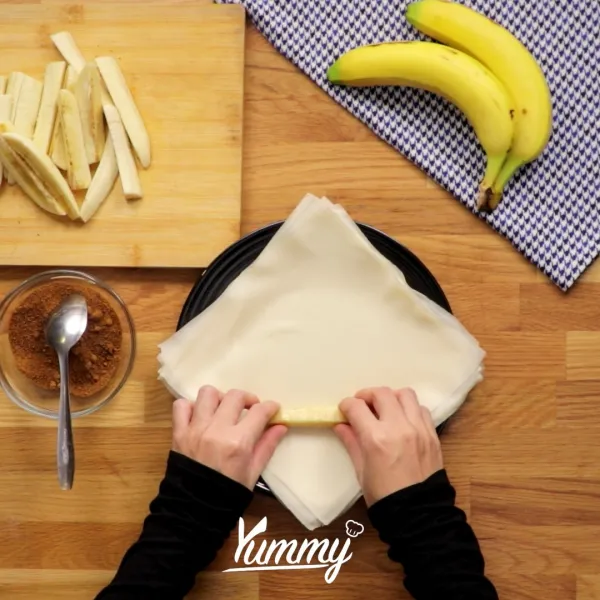 Siapkan kulit spring roll.Letakkan pisang dan gula palem, kemudian bentuk menyerupai lumpia, rekatkan dengan putih telur.