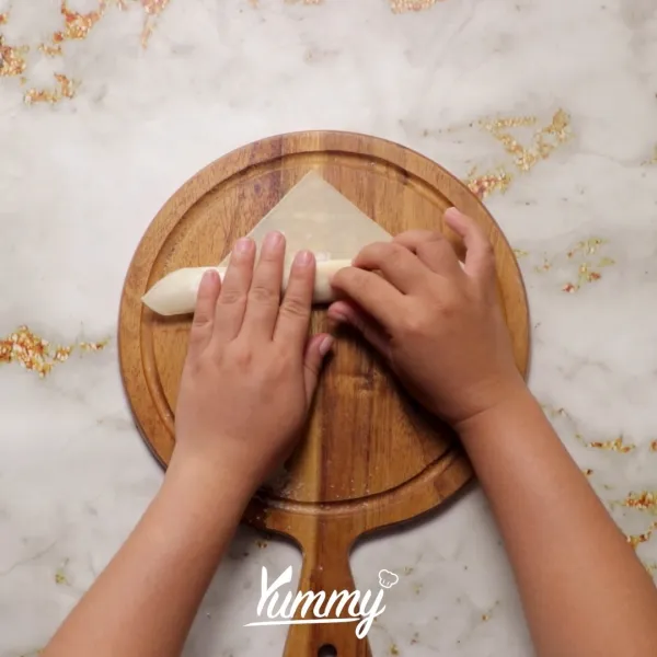 Gulung kulit lumpia lalu rekatkan bagian ujungnya dengan air.