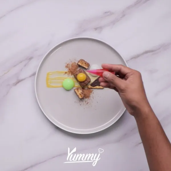 Tambahkan saus strawberry dan blueberry serta susu bubuk sebagai hiasan.