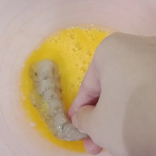 Kocok telur, kemudian celupkan udang satu per satu.
