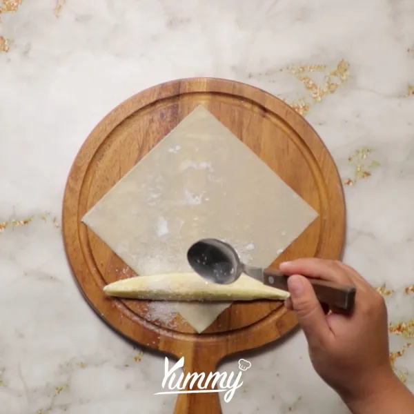 Letakkan pisang diatas kulit lumpia. Taburi dengan gula pasir.
