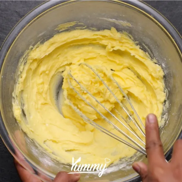 Campurkan mentega dan gula halus dalam satu wadah. Kocok dengan wisk hingga tercampur rata.