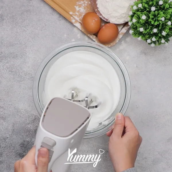 Kocok putih telur dengan mixer hingga ½ kaku, kemudian masukkan gula pasir secara berkala ke dalam putih telur. Kocok hingga membentuk meringue. Sisihkan.