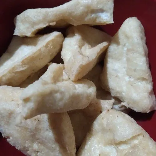 Potong tahu bentuk segitiga lalu goreng kering.