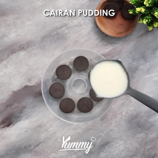 Susuk potongan oreo di dasar cetakan pudding, lalu beri sedikit campuran pudding, biarkan hingga sedikit mengeras.