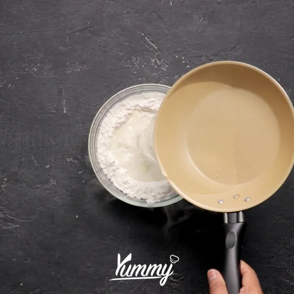 Tambahkan air hangat ke dalam campuran tepung lalu aduk rata hingga tercampur dan kalis, lalu ambil satu sendok adonan dan pipihkan. Letakkan telur puyuh di atasnya lalu gulung hingga berbentuk bulat (lakukan hingga adonan habis).
