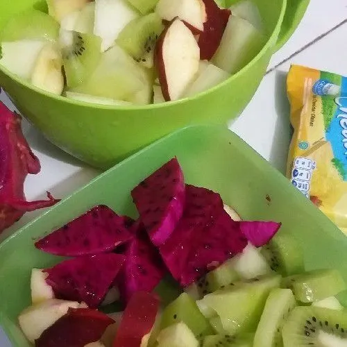 Potong buah berbentuk dadu dengan ukuran sedang.