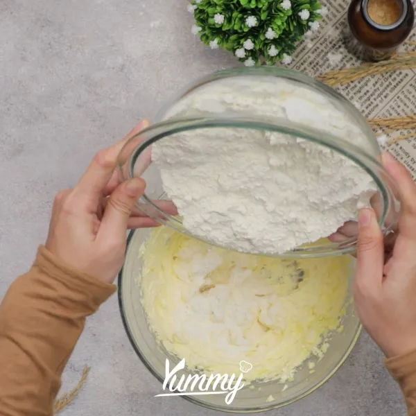 Masukkan bahan tepung ke adonan telur secara bertahap, aduk dengan spatula hingga merata.