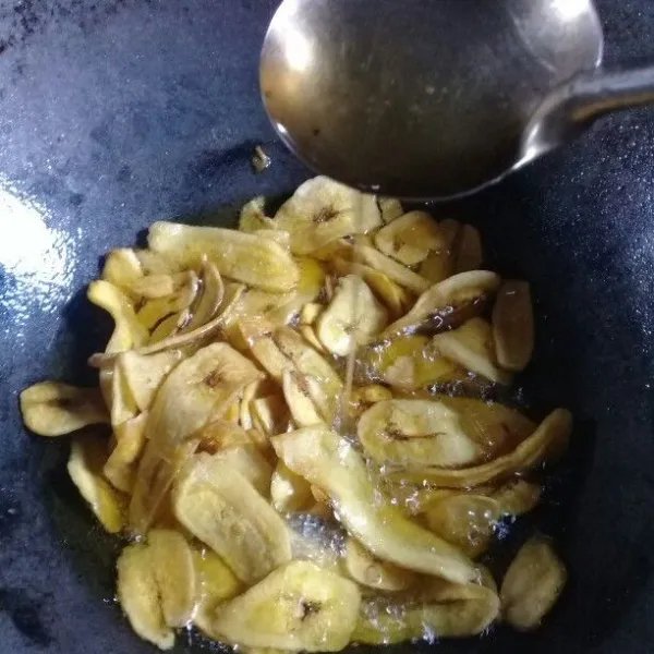 Setelah pisang berwarna agak kuning keemasan, tuangkan larutan gula ke dalam pisang. Aduk-aduk supaya merata.