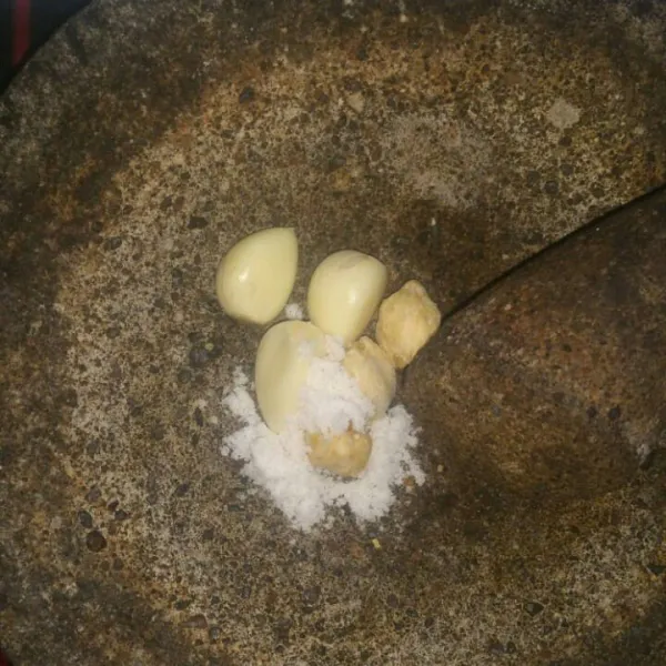 Haluskan bawang putih, kemiri, dan garam.