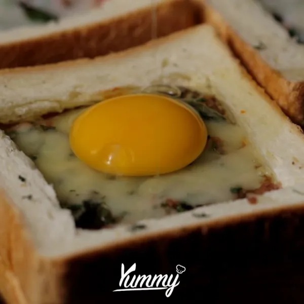 Keluarkan roti dari oven lalu tambahkan satu butir telur diatasnya. Lalu oven lagi dengan suhu 200 C selama 10 menit hingga matang.