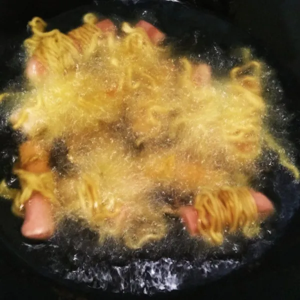 Kemudian siapkan minyak panas di wajan, goreng satu persatu sosis yang telah di gulung dengan mie hingga berwarna kuning dan agak kecoklatan.