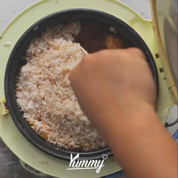 Masukkan air kaldu dan beras, aduk rata. Masak hingga matang.