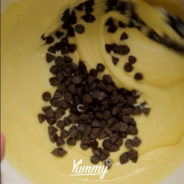 Kocok dengan kecepatan tinggi mentega, gula. Kocok hingga putih dan mengembang. Kurangi kecepatan mikser, masukkan telur satu per satu. Masukkan susu dan chocolate chip dan vanila. Aduk merata.