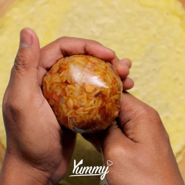 Cetak bulat nasi dengan plastik lalu bungkus dengan telur dadar. Setelah itu hias bekal sesuai selera.