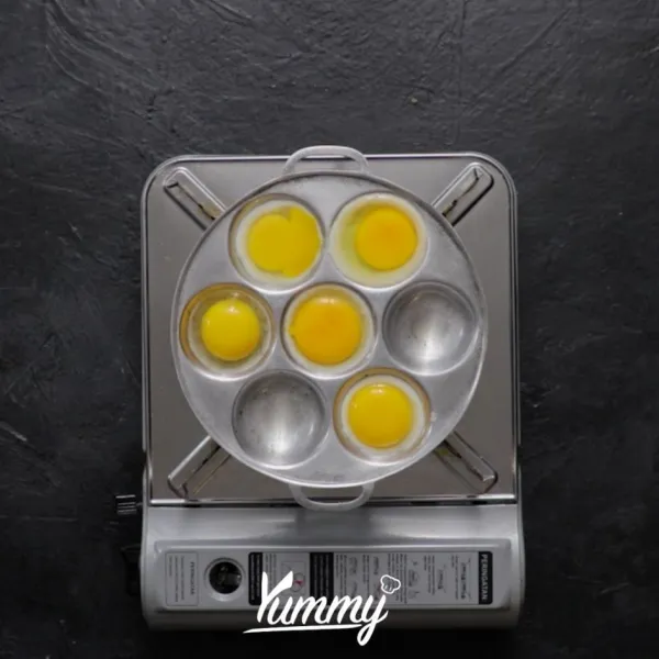Tambahkan telur, dengan cara pecahkan telur di atas cetakan.