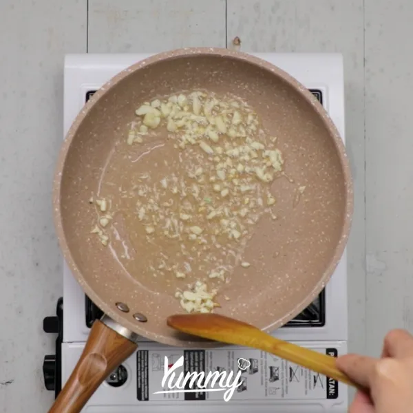 Panaskan minyak pada teflon, tumis bawang putih hingga harum dan layu.