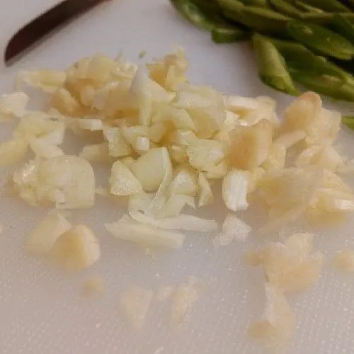 cCincang kasar bawang putih.