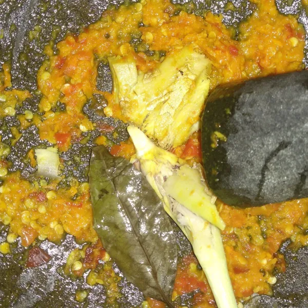 Haluskan semua cabe rawit, 2 buah bawang putih, dan kunyit sampai harum. Kemudian iris tipis sisa bawang putih dan bawang merah.
