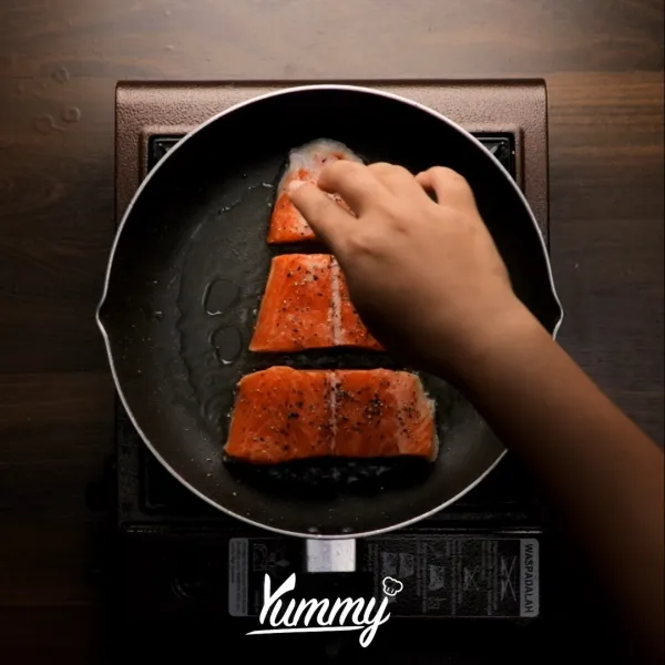 Panaskan minyak zaitun dalam wajan dengan api sedang, masak salmon selama 3 menit pada setiap sisi. Angkat.