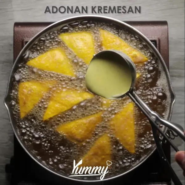 Tuangkan adonan kremesan ke atas tahu. Masak hingga adonan kremesan matang, keras, dan kecoklatan.