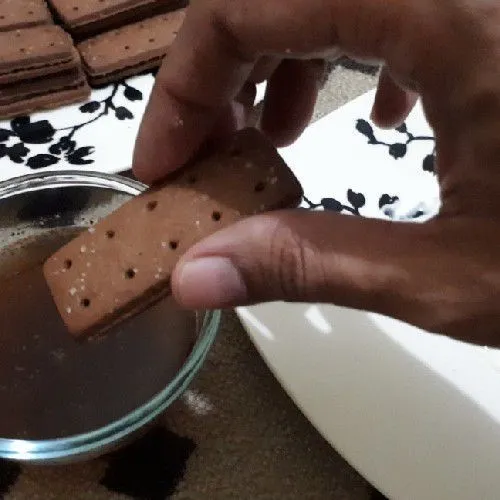 Celupkan biskuit cokelat pada larutan kopi.