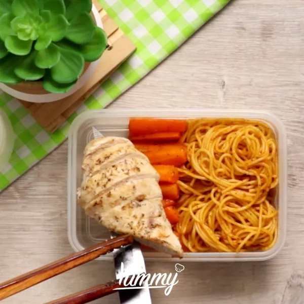 Sajikan spaghetti wortel dan ayam dalam lunch box.