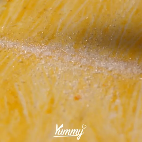 Setelah rata, taburkan gula ke atas permukaan puff yang telah dioles dengan kuning telur.
