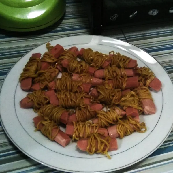 Gulung sosis satu persatu dengan mie yang sudah di siapkan tadi, seperti gambar ini.