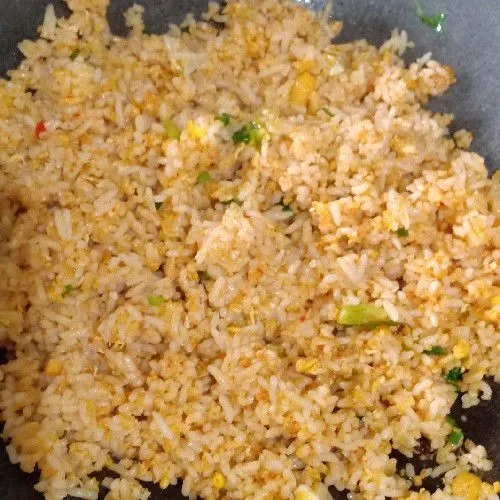 Masukkan nasi, aduk hingga rata masak dengan api sedang, koreksi rasa.
