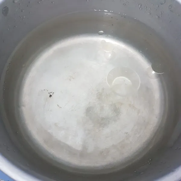 Rebus air di dalam panci dan tambahkan 1 sdt minyak serta garam agar saat merebus pempek tidak lengket.