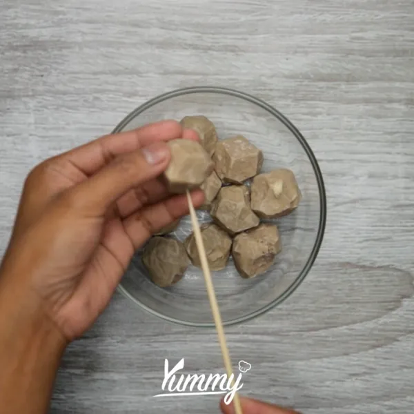 Tusuk 3 pcs bakso dengan tusuk sate. sisihkan.