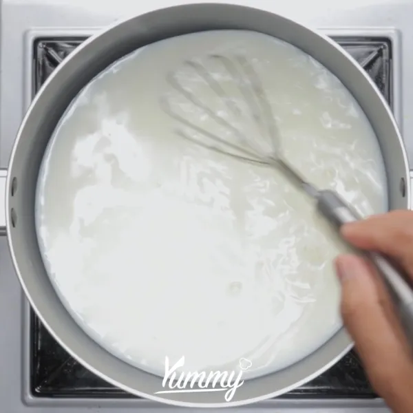 Campurkan susu cair, gula dan perasa vanila dalam sauce pan. Aduk hingga tercampur rata.