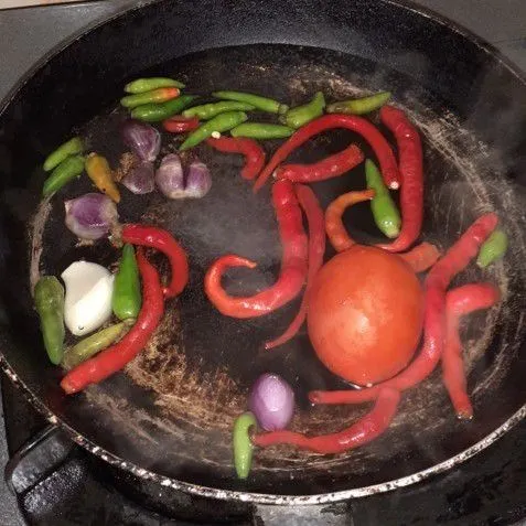 Panaskan air, rebus buah tomat, cabai merah, cabai rawit, bawang merah dan bawang putih.
