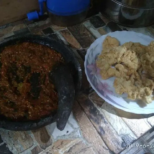 letakkan ayam ke dalam piring saji tambahkan sambal diatasnya sajikan bersama nasi dan lalapan