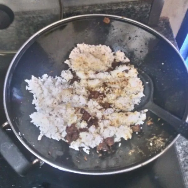 Masukkan nasi putih, aduk hingga benar-benar rata. Tambahkan mentega, aduk rata kembali. Angkat.