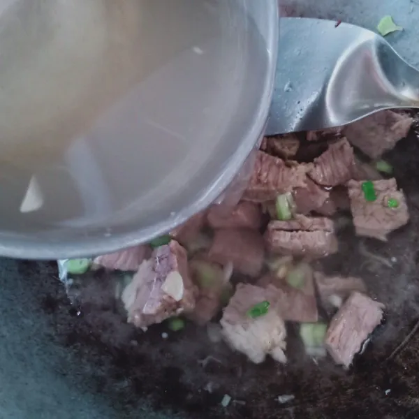 Masukkan daging dan tambahkan air kaldu daging, didihkan.