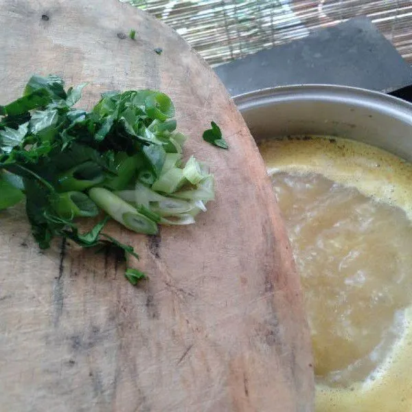 Masukkan potongan daun bawang dan seledri ke dalam kuah kaldu.