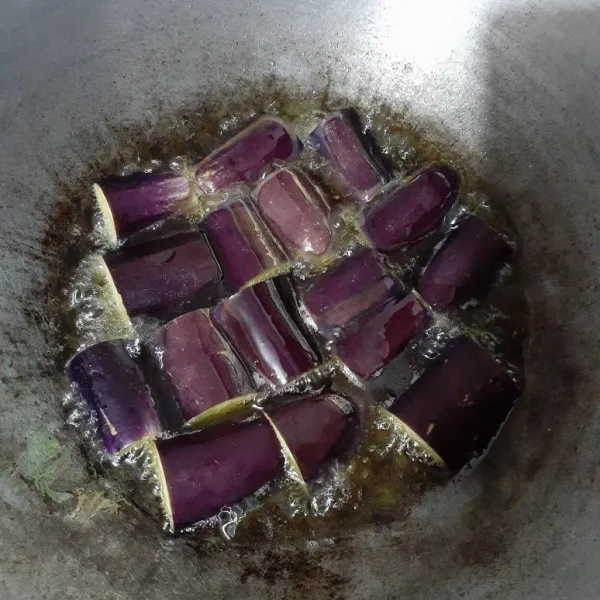 Goreng terong yang sudah di potong-potong dan belah 2 bagian dengan minyak panas sampai matang, sisihkan.