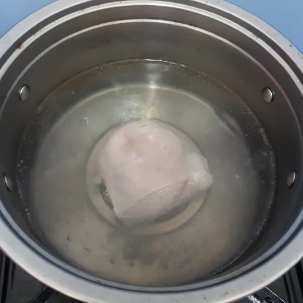 Rebus air kemudian masukkan dada ayam, rebus hingga matang.