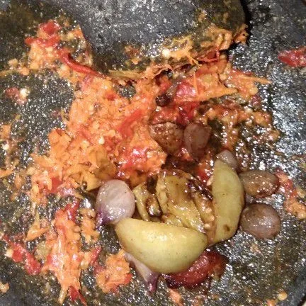 Setelah halus, tambahkan bawang merah dan tomat, ulek sampai tercampur dan bawang masih agak kasar.