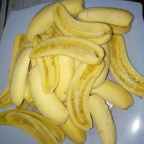 Potong / belah pisang menjadi dua bagian.