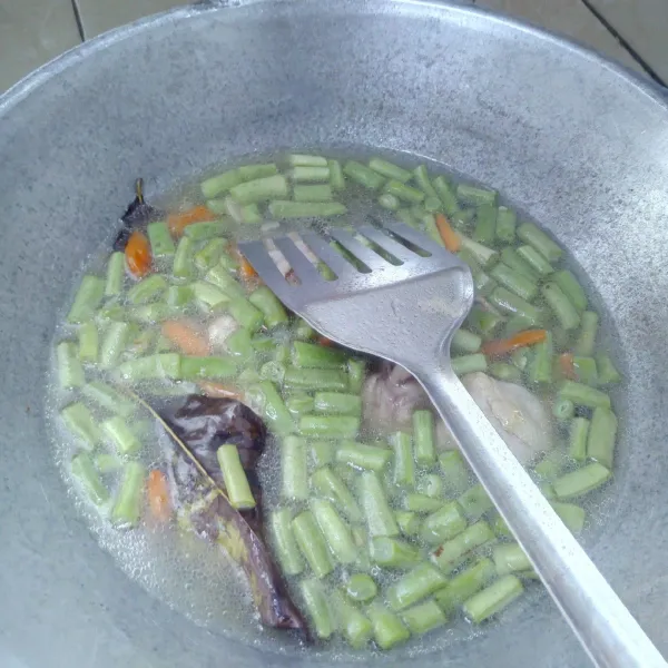 Masukkan buncis dan wortel, kemudian masak hingga sayuran matang.