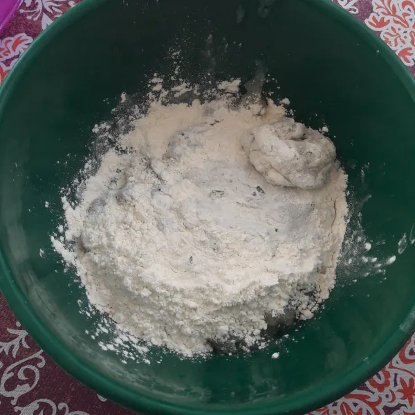 Pindahkan adonan tapioka dalam loyang, tambahkan tepung terigu sedikit demi sedikit, sambil diaduk dengan tangan.