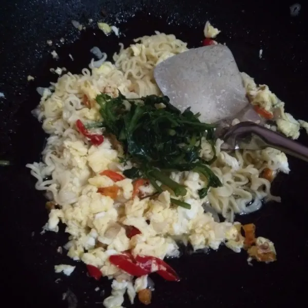 Masukkan mie instan dan bayam, aduk hingga rata.