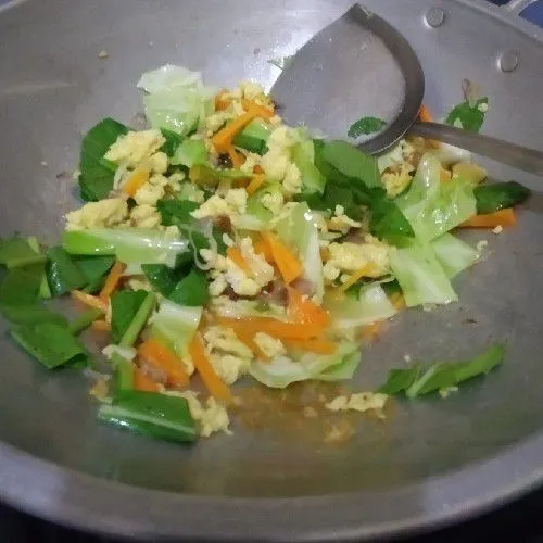 Setelah telur masuk, masukkan sayur yang sudah di potong-potong, kecap ikan, kecap manis, garam dan gula. Masak sampai sayur agak layu.