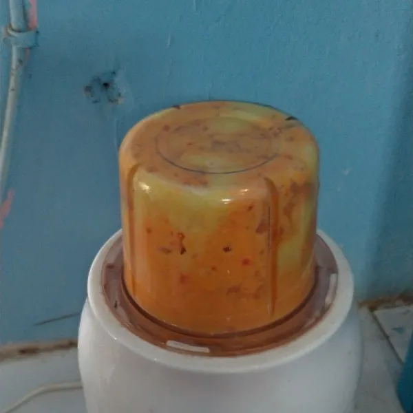 Blender bumbu halus bawang putih, bawang merah, kunyit, dan kemiri.